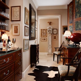 The custom bar matches the furniture throughout with a vibrant animal area rug.