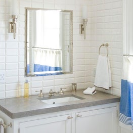 A guest bathroom features subway tiling and polished nickel finishes. 