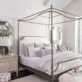 Luxurious lavender master bedroom, rubbed brass canopy bed, antique side tables
