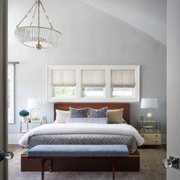 Vaulted ceilings and a wall of windows make this bedroom airy and bright. 