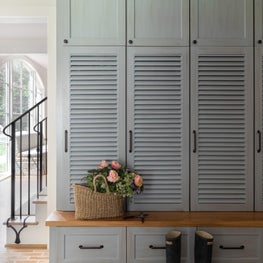 With louvered locker doors and brick flooring, this mud room is as charming as it is functional.