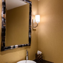 Powder Room with faux ostrich wallpaper and horn mirror.