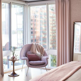 Relaxing corner in Tribeca master bedroom complete with womb chair and city view
