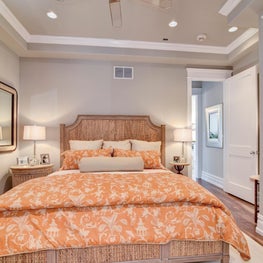 Guest bedroom with orange bedding and window treatments