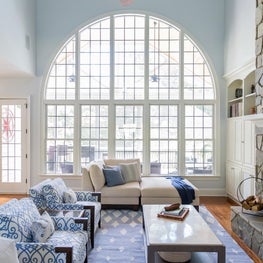Layered coastal living room with large window