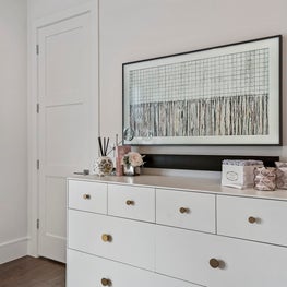 Modern boho girls bedroom; white dresser, gold hardware & contemporary wall art.