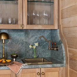 From the penny gap planking to the French curve detail at the faucet, there is no shortage of architectural charm in this home bar.