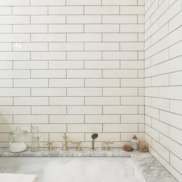Charming built in tub with subway tiled wall detail 