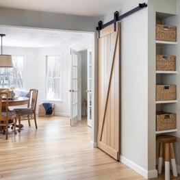 Natural oak barn door kitchen pantry with bronze hardware and breakfast room.