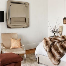 Portfolio: Warm primary bedroom with sitting area and artful pieces