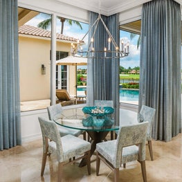 Expansive Decadent Waterfront, breakfast nook, eat in kitchen, glass top dinning table, teal curtains, marble floors, picture window