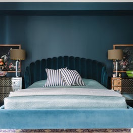 Art Deco Bedroom with teal walls, velvet bed, and mirrored nightstands 