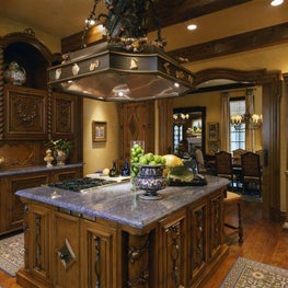 By emphasizing the detail and rich material of cabinets and vent hood; a smallish kitchen feels as impressive as one on a grand scale.