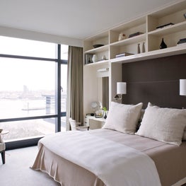 Master Bedroom in NYC apartment, upholstered wall, built in shelving, city view