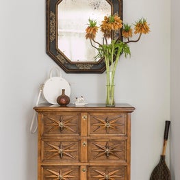 Eclectic Los Angeles Entry with Antique Mirror and Mid-Century Case Piece