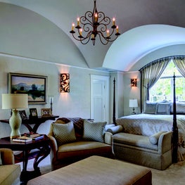 Oversized chairs and ottoman:custon sized sconces in vaulted ceiling bedroom