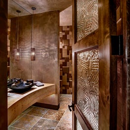 Personalizing the space with a shimmery, specialty finish achieves the unexpected in this powder room  