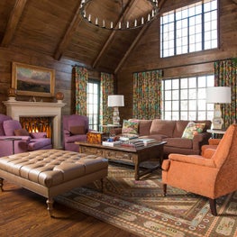 Purple, orange, and brown make a cozy and visually pleasing wood paneled Family Room