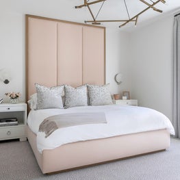 Portfolio: A tall pink headboard with white bedding and geometric chandelier.