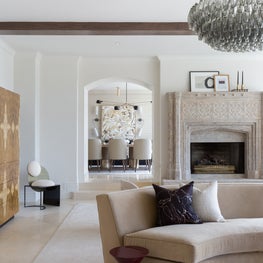 Portfolio: A Murano chandelier hangs above a serpentine sofa with burl wood cabinet.