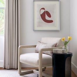 Portfolio: White lounge chair and dark accent table in a modern guest bedroom