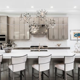 SLEEK CONTEMPORARY METALLIC RESIDENCE, silver kitchen cabinets, large island, eat in kitchen, chandelier in kitchen, artistic light fixture