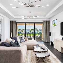 SLEEK CONTEMPORARY METALLIC RESIDENCE neutral modern open concepts. Raw edge mid century moden coffee table, beige sofa, modern chandelier, coastal