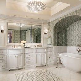 This master white bathroom has one wall with a green patterned wallpaper creating a tropical vibe.