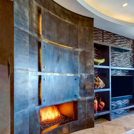 Taking a cue from the room’s architecture, this curved fireplace surround creates an elegant focal point