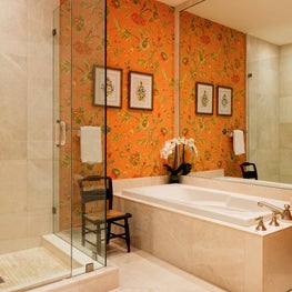 A mirrored wall opens up this warm inviting bath.