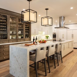 This renovated custom white kitchen features a dark wood builtin which softens the ambiance.