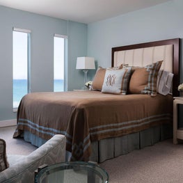 The dark wood bed frame in the master bedroom juxtaposes the soft blue walls.