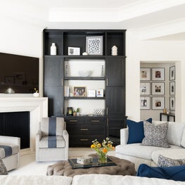 Portfolio: Traditional living space with lots of seating for a large family and floor to ceiling dark stained built ins with shelving and cabinets