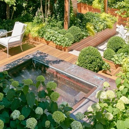 A verdant master terrace is complete with a hot tub and breakfast nook. 