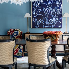 Blue-lacquered dining room with pops of rich color and brass accents 