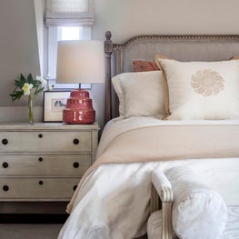 Bedroom w/ red lamps, divan, Swedish chest bedside tables, grey linen velvet bed