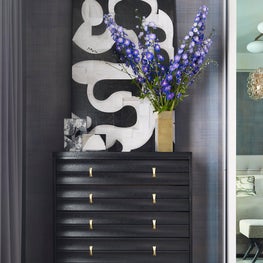 Modern master bedroom with mid-century furniture and graphic art.