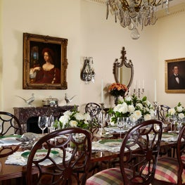 A fine chandelier is suspended above the glossy wood dining table.
