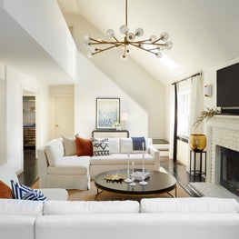 Hamptons Living Room with white sofas, high ceilings and statement chandelier