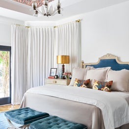 Master Bedroom with Upholstered Headboard, Benches, and a Wallpapered Ceiling