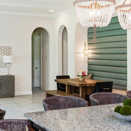Open plan kitchen with contemporary beaded chandeliers over island. 