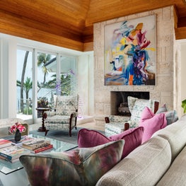 Ceiling high stone fireplace topped by a bold oil on canvas by Miriam Schapiro.