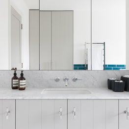 Tongue and groove detail in family bathroom with carrera marble tops 