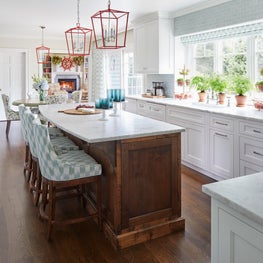 Glenview Kitchen. White kitchen with wood island, quartzite counter, blue and celadon accents, ikat print & red pendants.