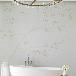 Inviting stand-alone tub sits against a bespoke cherry blossom mosaic wall 