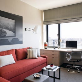 Study in NYC apartment, built in desk, black and white artwork, orange accents 
