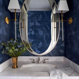 With shades of deep blue and gray-veined marble this drama-filled powder bath is sure to impress every guest.