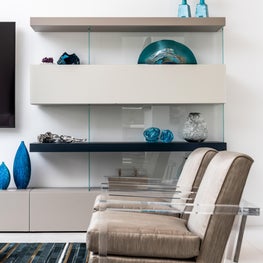 LAKEFRONT CONTEMPORARY VILLA, floating shelves, lucite arm chair, art glass, modern rug, teal blue glass, modern den, modern living room