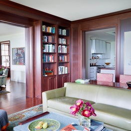 A study with wood paneled walls & built in bookcases
