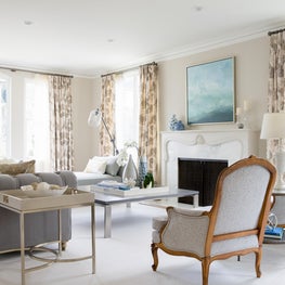 Transitional living room with gray tufted chesterfield sofa and stone fireplace.